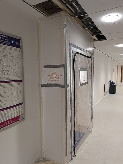A construction tent over a door in a corridor, indicating that building work is going on inside.